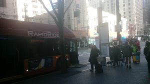 Rider boarding bus on Third Ave in downtown Seattle