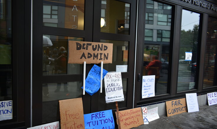 Signs made by counter-convocation participants decorate Seattle Colleges District's headquarters