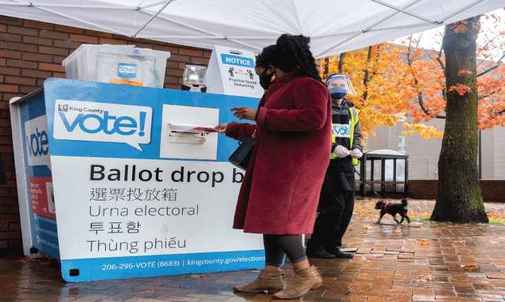 A voter turns in her ballot at the ballot box