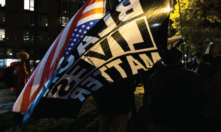 Election night protestors with upside down American flag and BLM flag