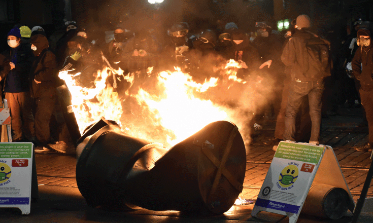 Protestors set a plastic drum ablaze