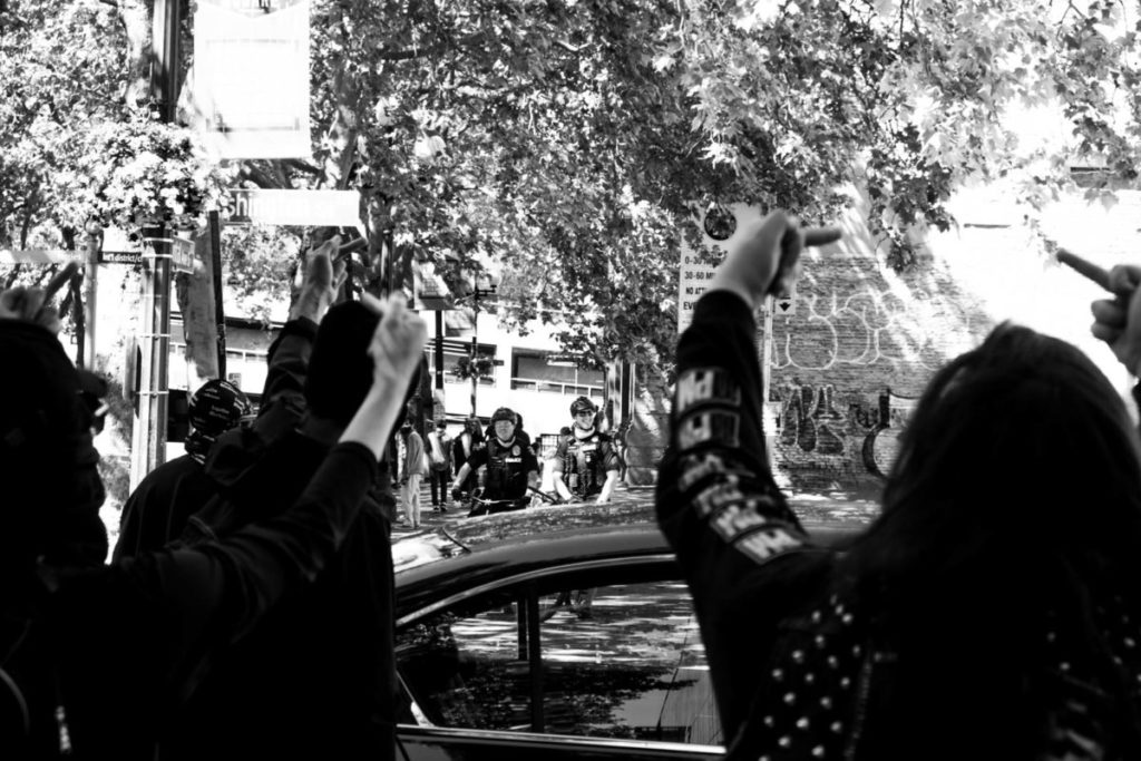 A group of protestors flip off officers standing across the street just as the march had commenced