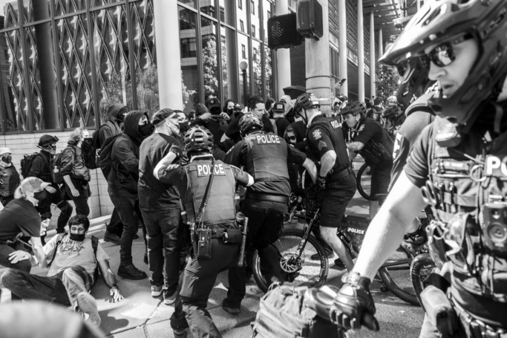 Police officers ride their bikes into the march, tackling and arresting several protesters