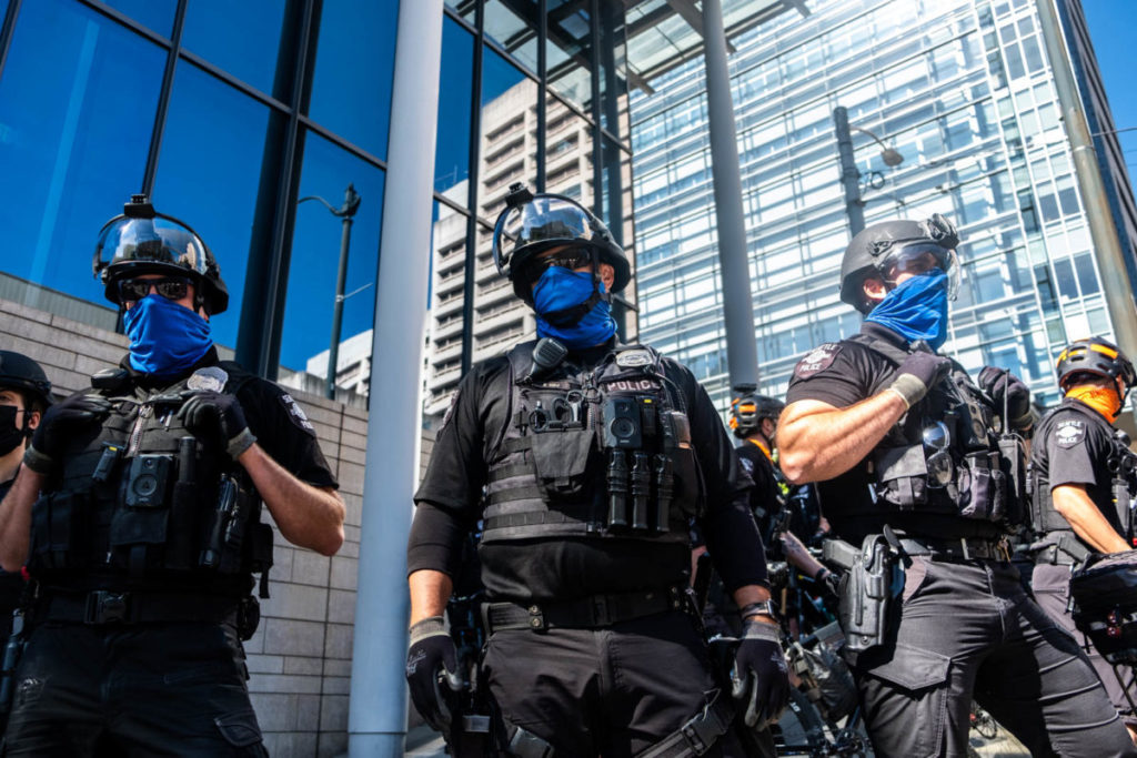 Three SPD officers guard an area that was recently cleared of protestors off of 4th Avenue