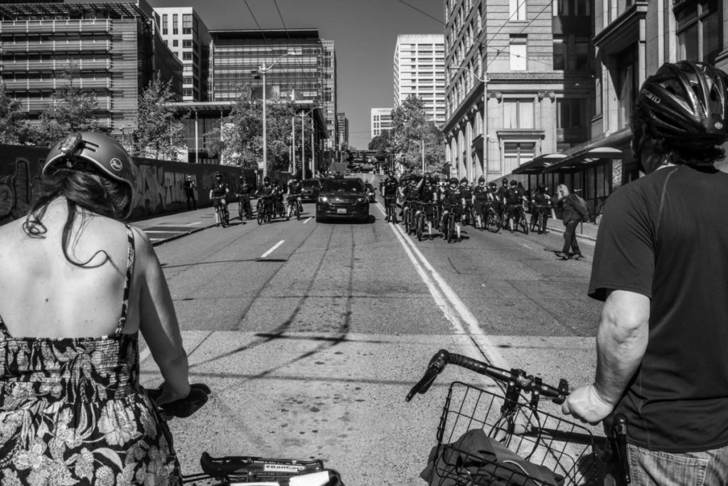 Two members of the bike brigade march look onward toward dozens of incoming policemen