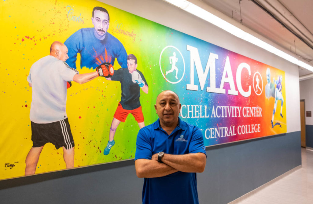 Hernandez in front of the mural commissioned in his honor