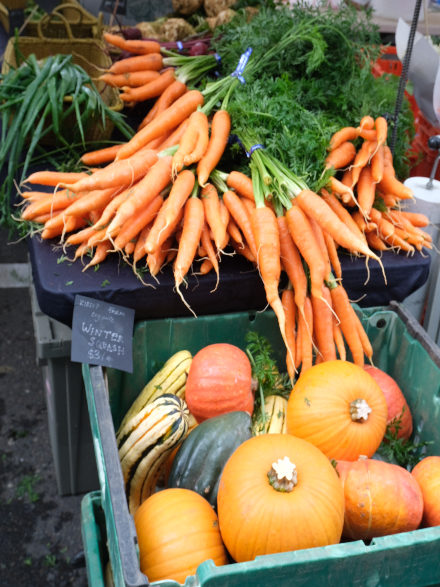 Fresh carrots and winter squash show off their vibrant orange color.