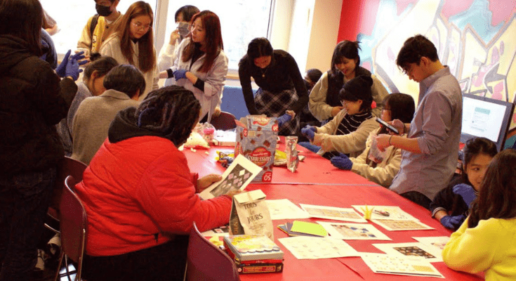Larger group of students sitting around table.